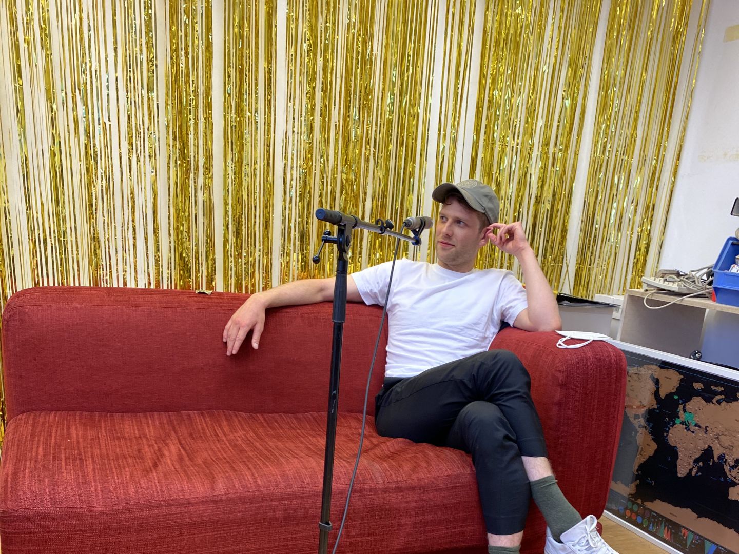 Silas Breiding sitzt auf einem roten Sofa