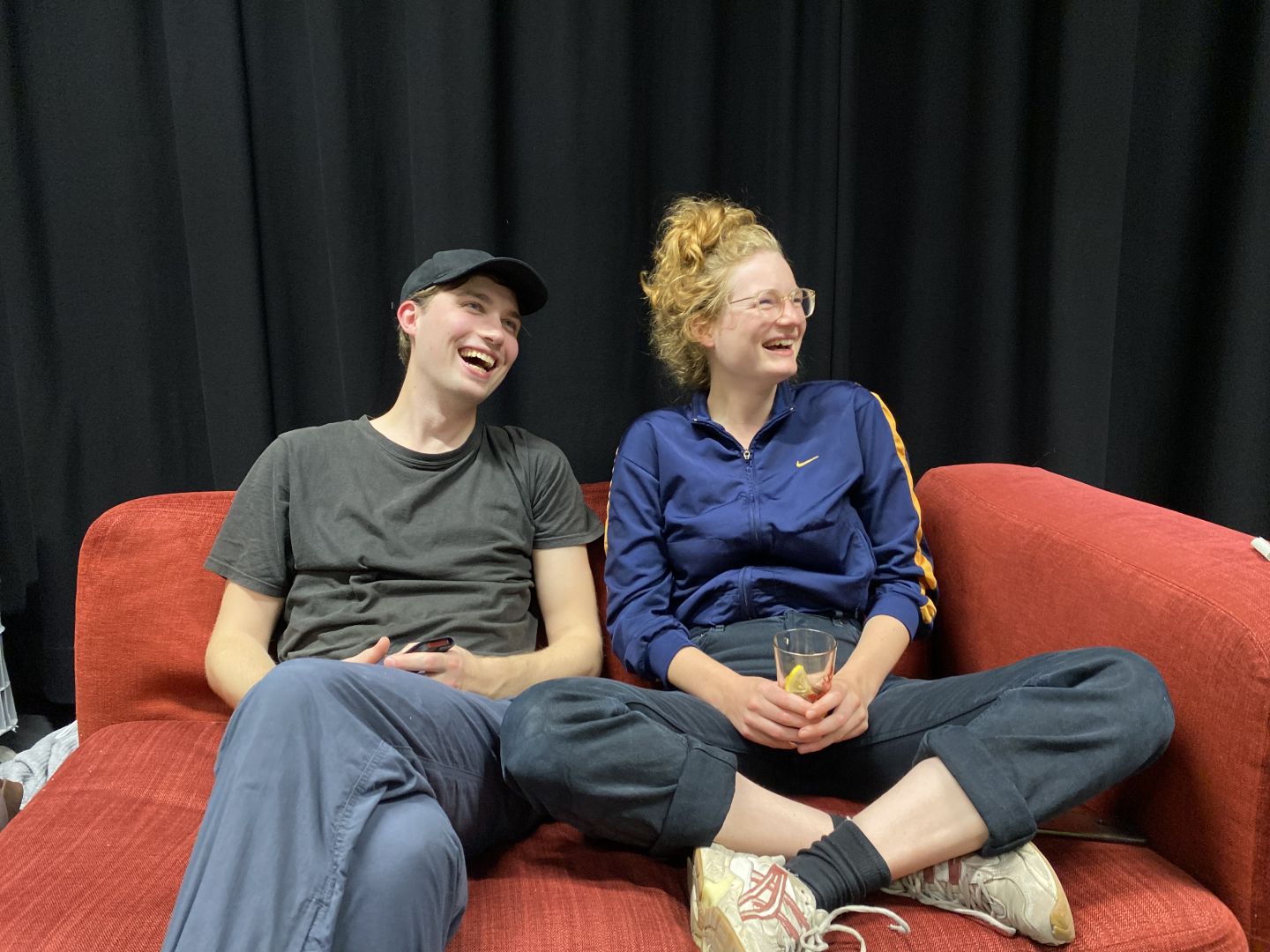 Liv Stapelfeldt und Janek Maudrich sitzen auf einem roten Sofa