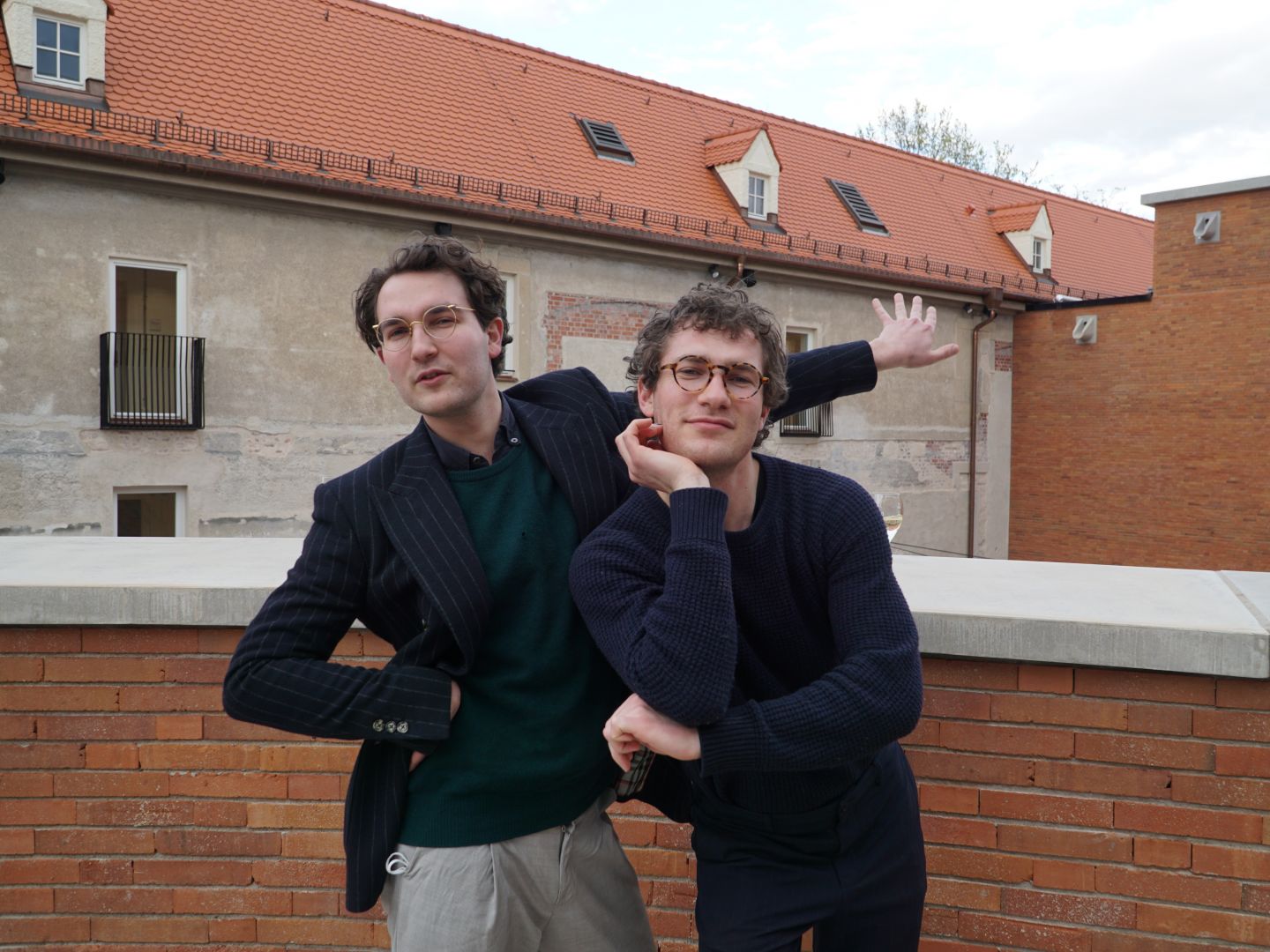 Das Bild zeigt Lukas und Nikolas Darnstädt vor einer Ziegelfassade.