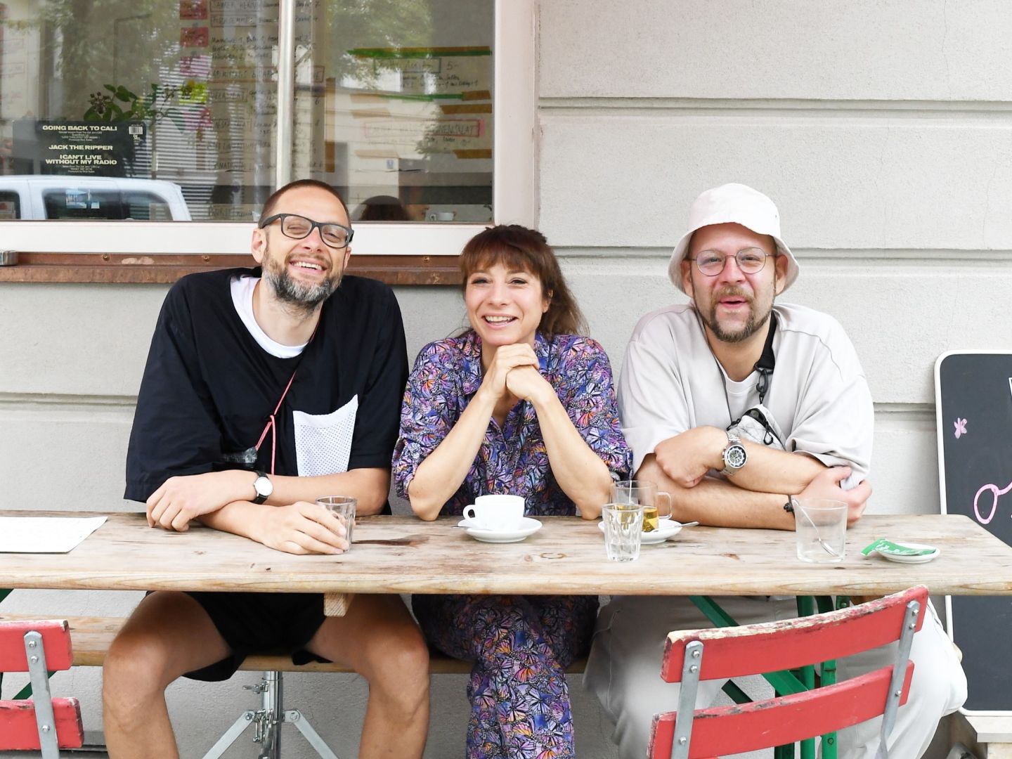 ein Foto von Nina Fiva Sonnenberg mit Benedikt Wiessmeier und Jakob Döring vor dem Café Mari