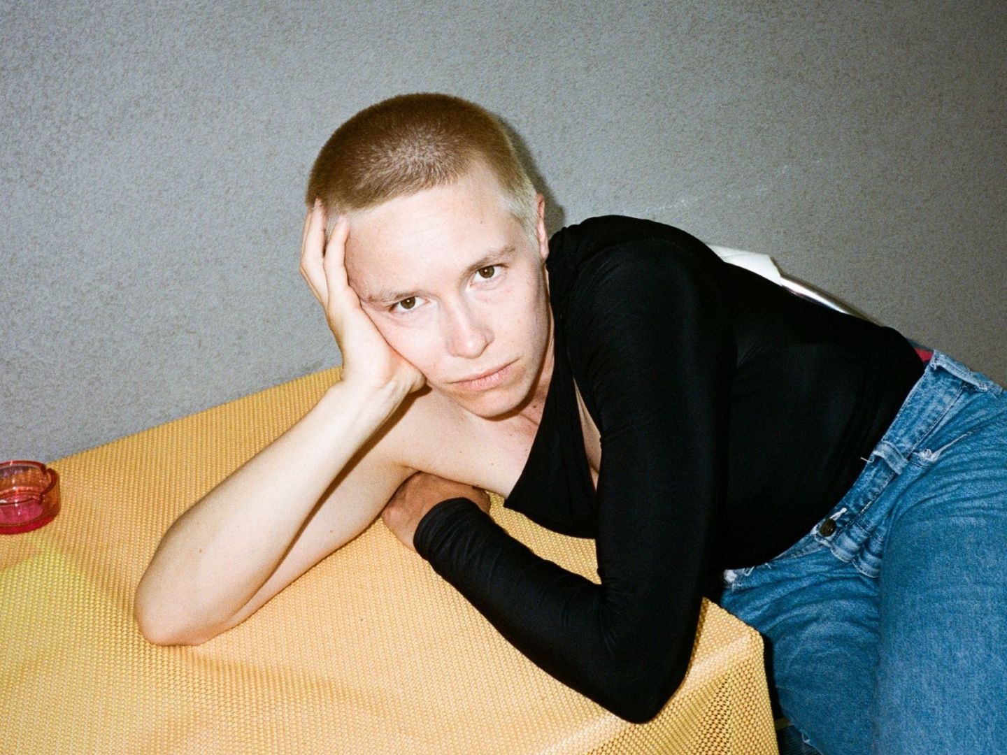 Portraitfoto von Anna Marboe, die ihren Kopf auf einem Tisch aufstützt