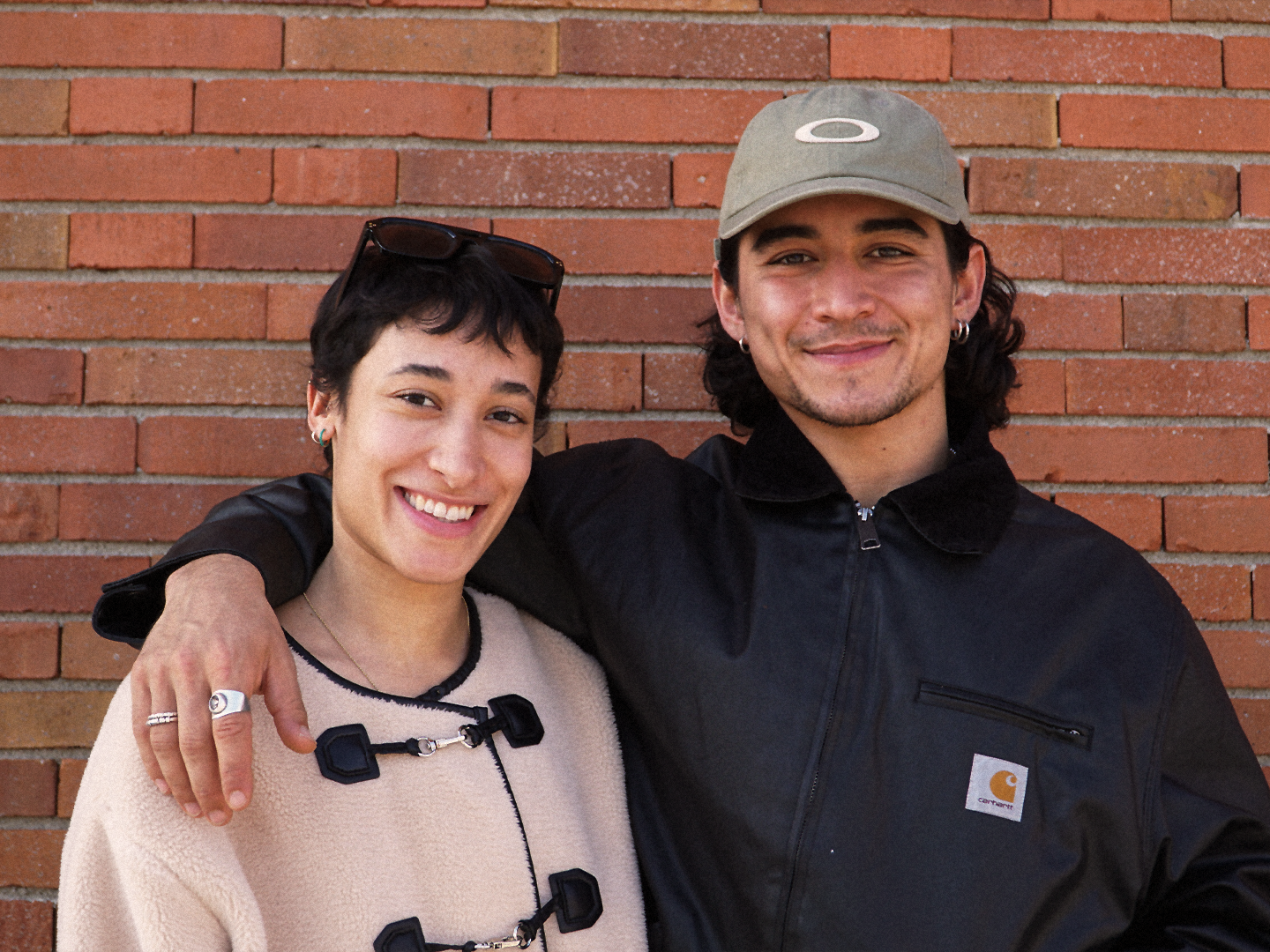 Das Regieduo Colindres Zühlke und Perhat vor der Backsteinwand des Münchner Volkstheaters.