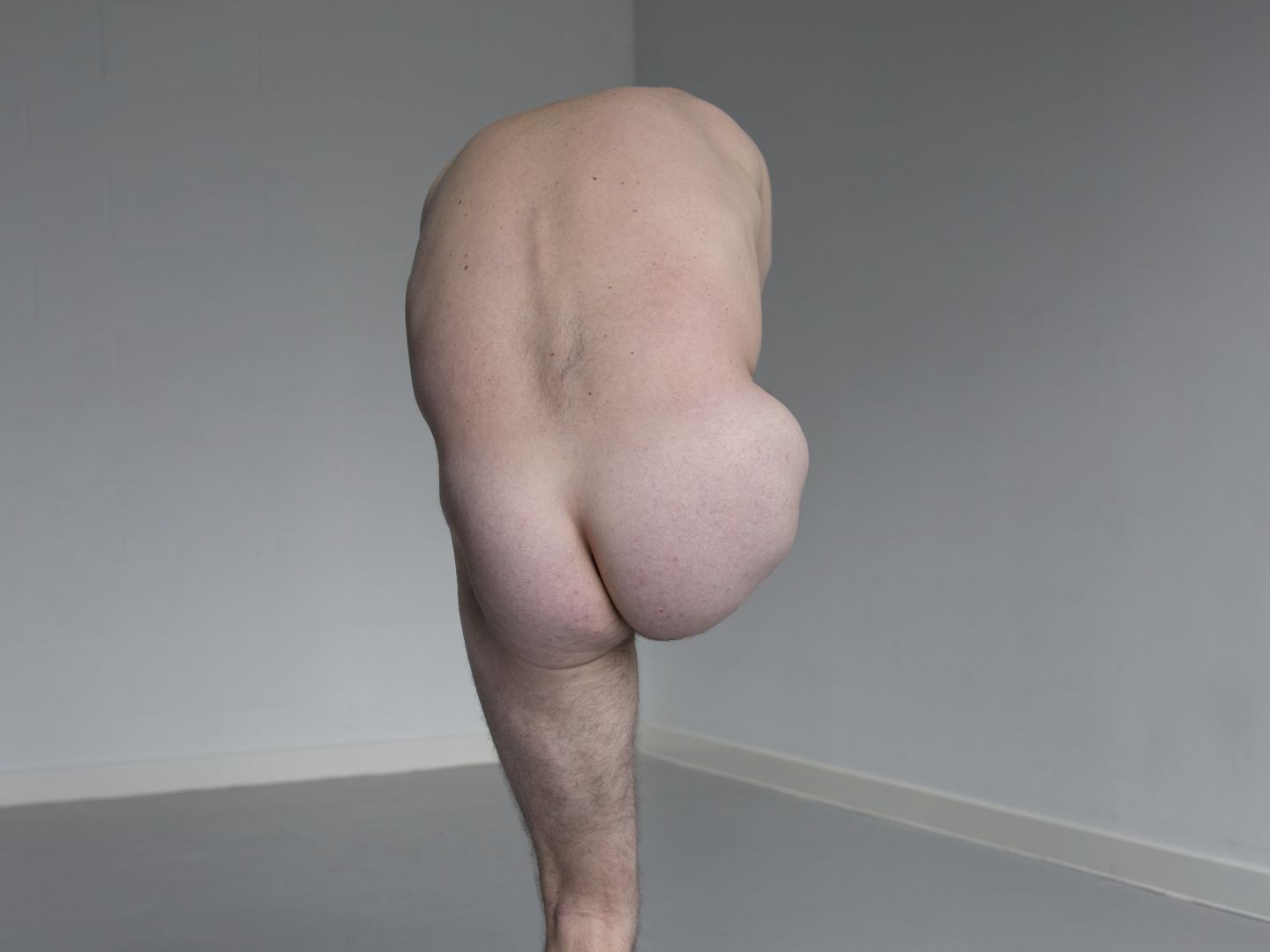 Plakatmotiv von Der Kaufmann von Venedig. Das Bild zeigt einen nackten Mann von hinten, auf einem Bein stehend.