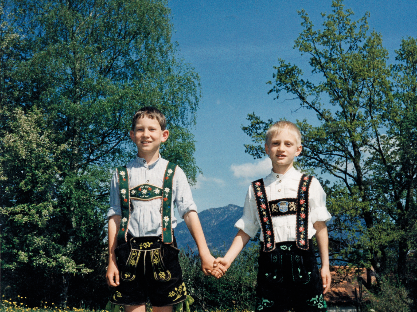 Zwei Jungen in bayerischer Tracht auf einer Bergwiese