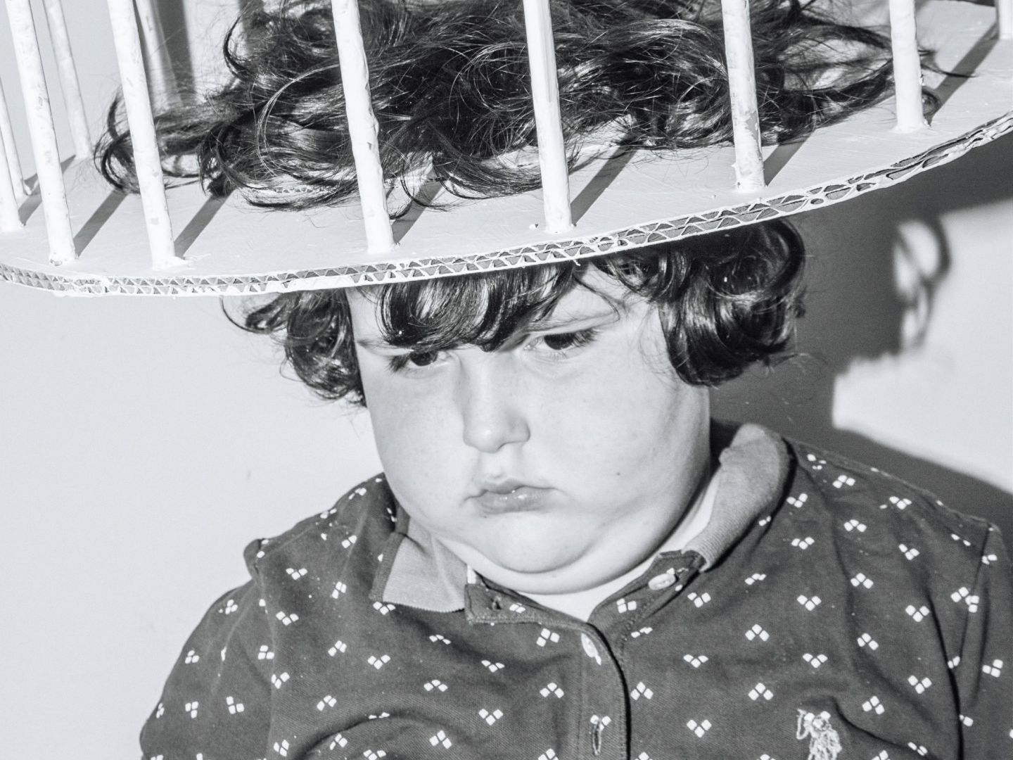 Das Bild zeigt ein Kind mit einem runden Käfig auf dem Kopf