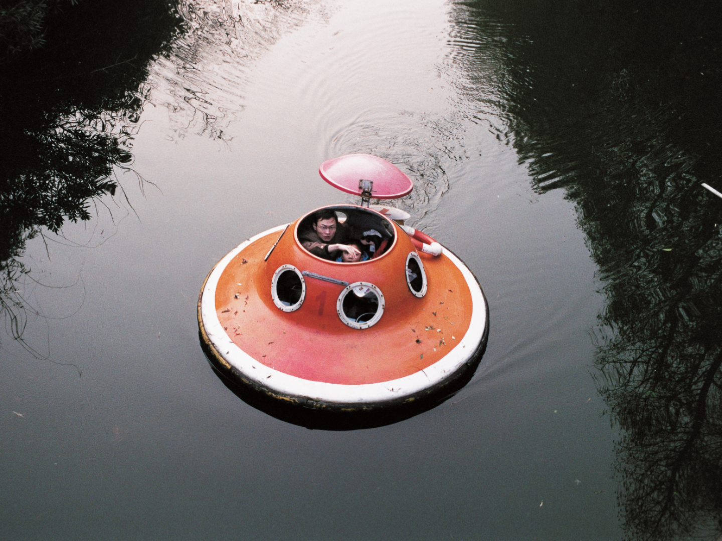 Das Foto zeigt ein UFO auf dem Wasser, drinnen sitzen Menschen.