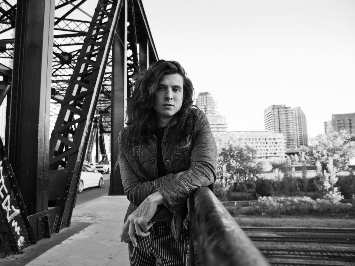 Ein Portrait von Billy Raffoul auf einer Brücke am Geländer gelehnt