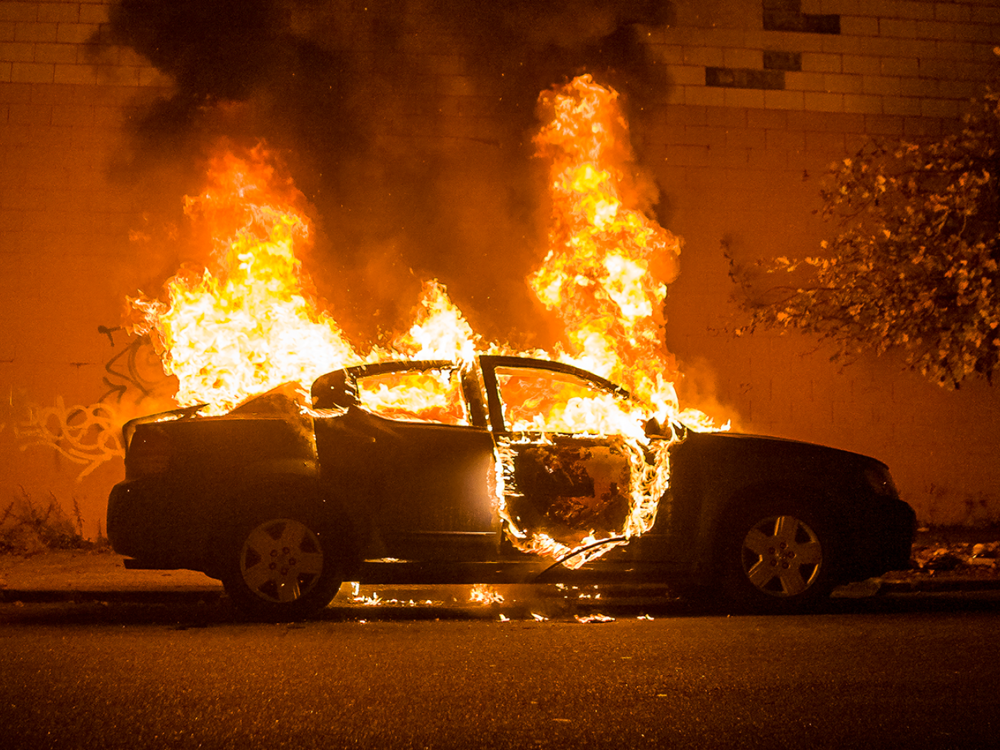 Ein brennendes Auto am Straßenrand