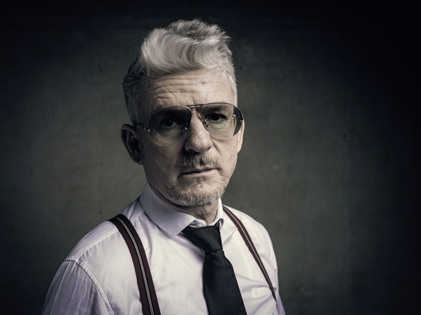 Das Bild zeigt eine Portraitaufnahme von Heinz Strunk. Er trägt eine Pilotenbrille.