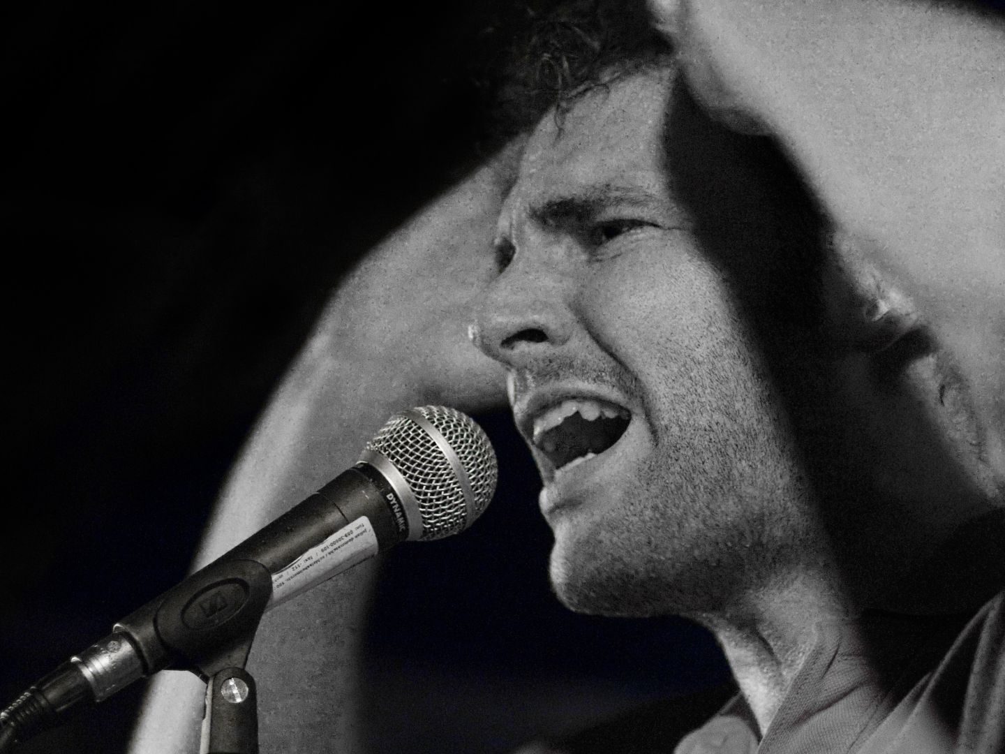 Ein Slammer auf der Bühne in schwarz-weiß