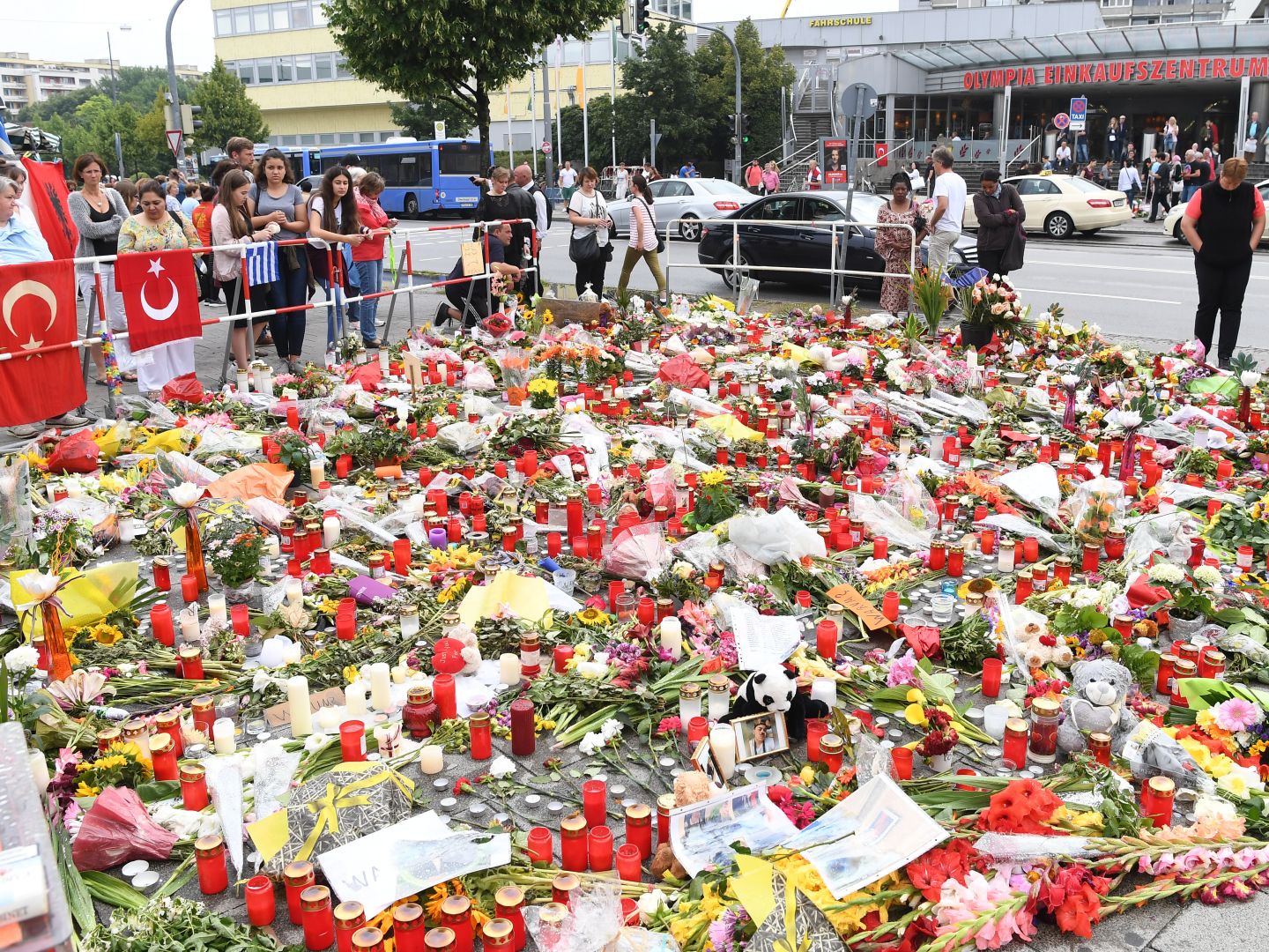Gedenkort mit niedergelegten Blumen, Bildern, Briefen und Grabkerzen