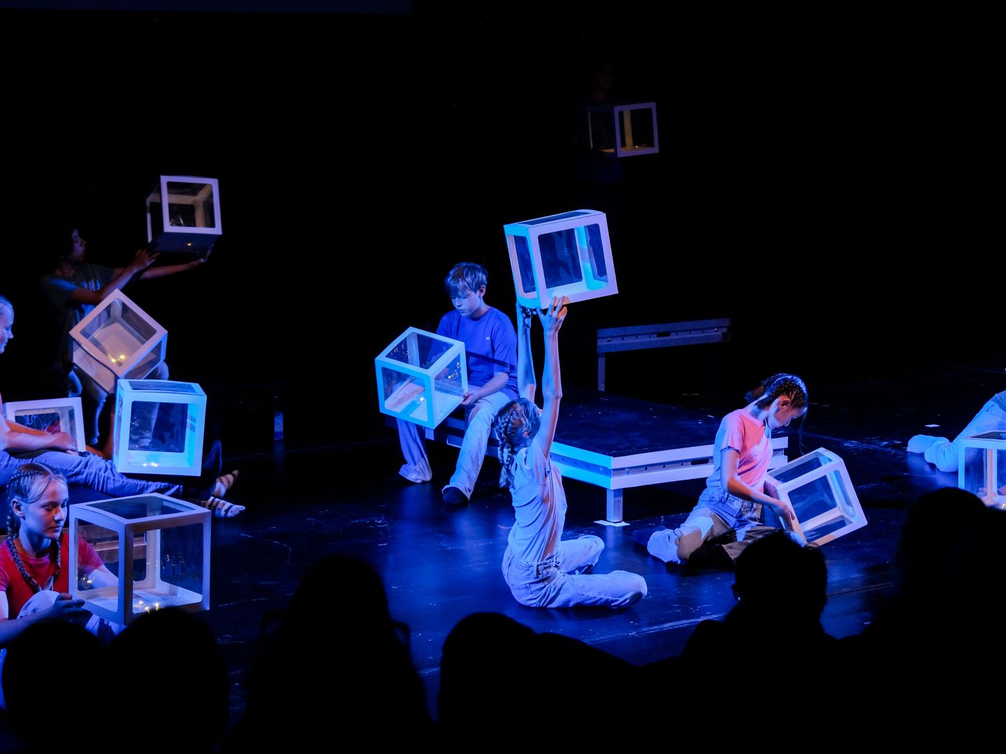 Jugendliche auf der Bühne zeigen ein Theaterstück.