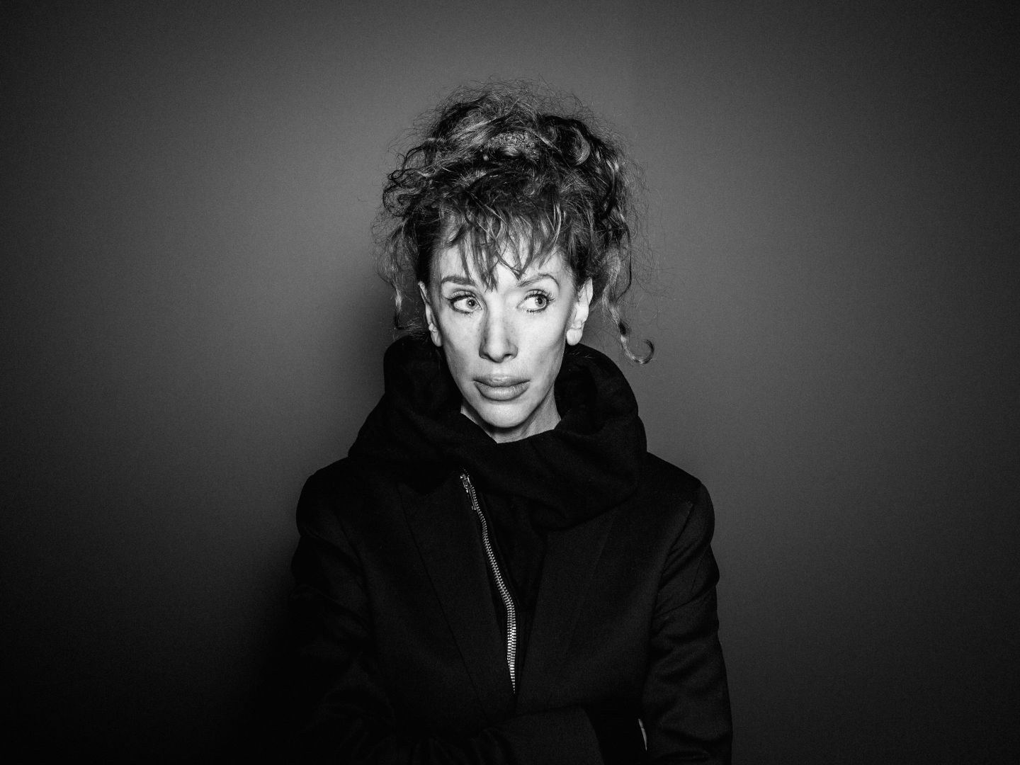 Schwarz-weißes Portrait von Sibylle Berg, sie trägt die Haare hochgesteckt und blickt nach oben rechts.