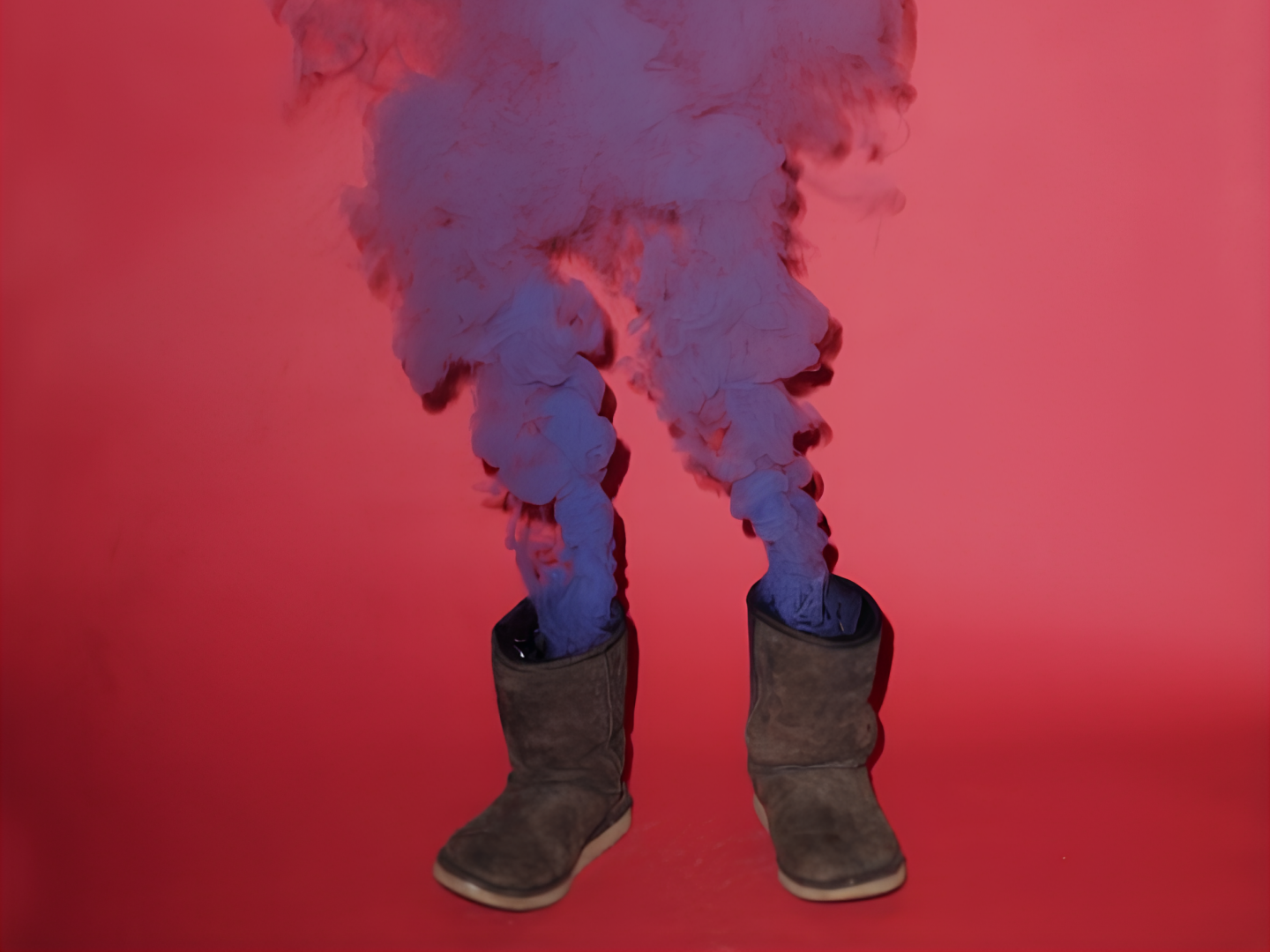 Zwei Ugg-Boots vor pinkem Hintergrund, aus denen lila Rauch aufsteigt.