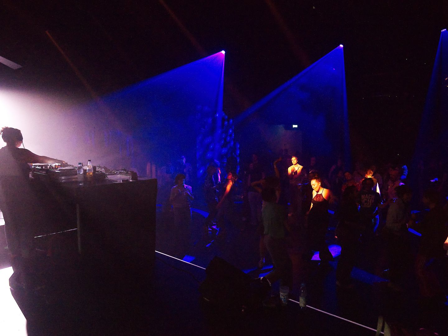 Ein Partyfoto vom Radikal jung 2025: links ist DJ Alba am Mischpult, rechts tanzt die Menge.