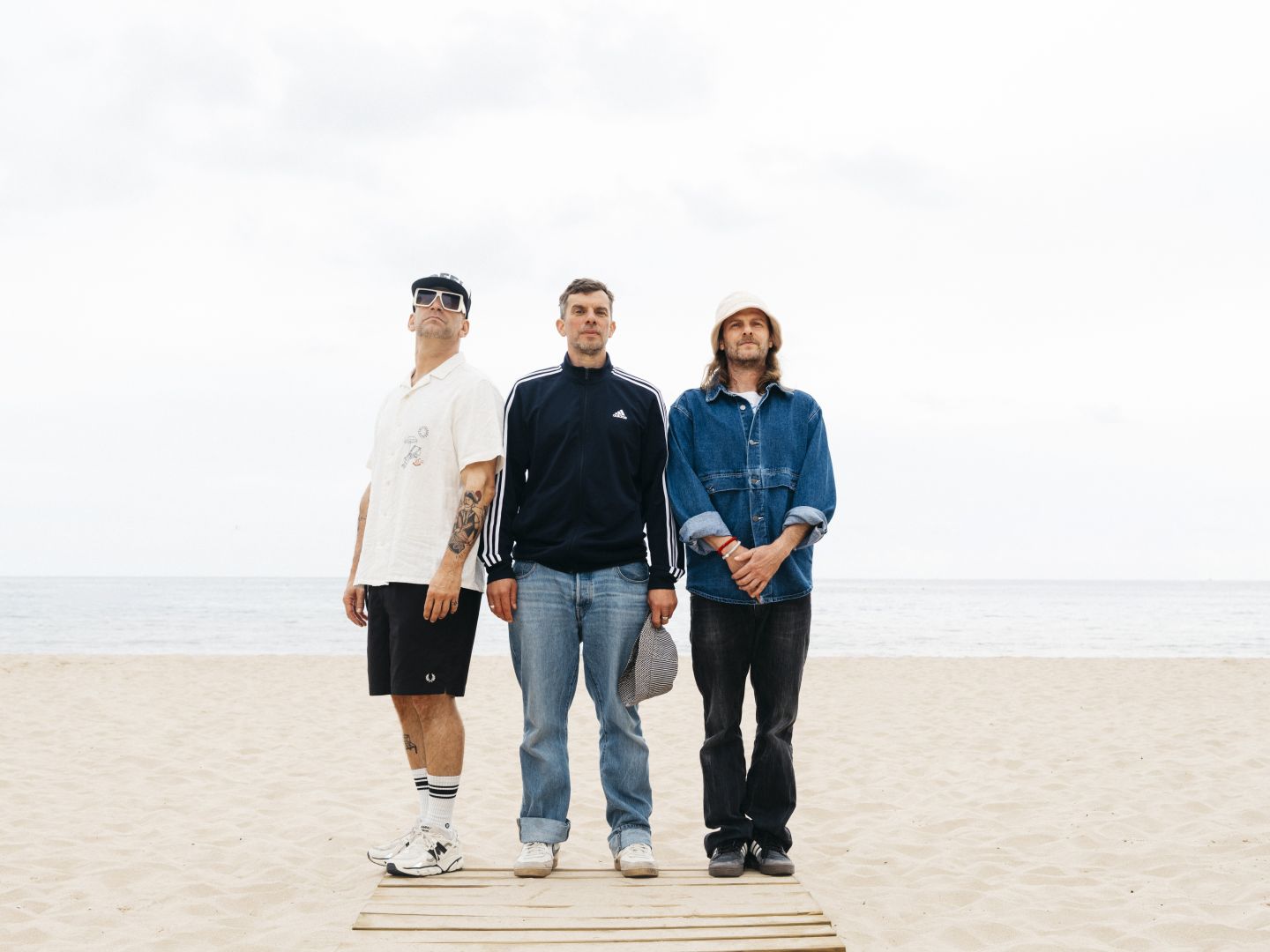Die Sportfreunde Stiller auf einem Steg am Strand.