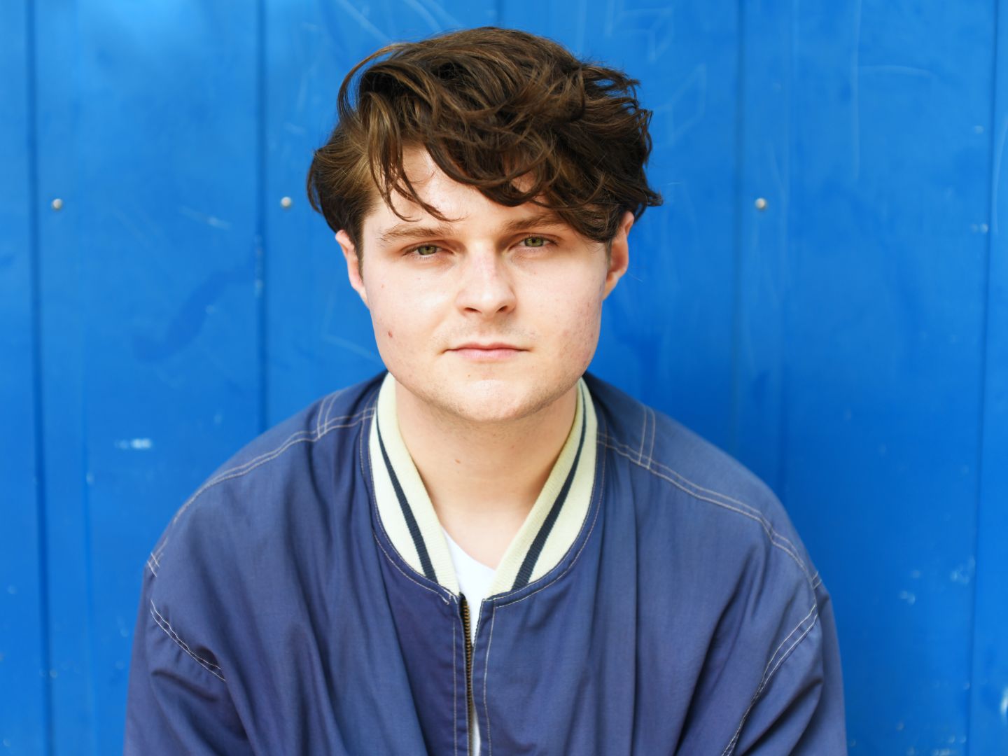 Portrait von Cedric Stern vor einer blauen Wand