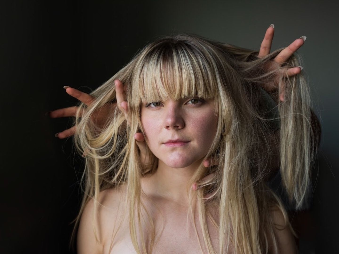 Ein Portraitfoto von Felicia Nilsson. Fremde Hände heben ihre langen Haare.