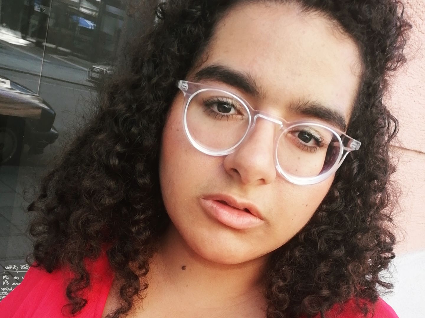 Frau mit lockigen Haaren und Brille. 