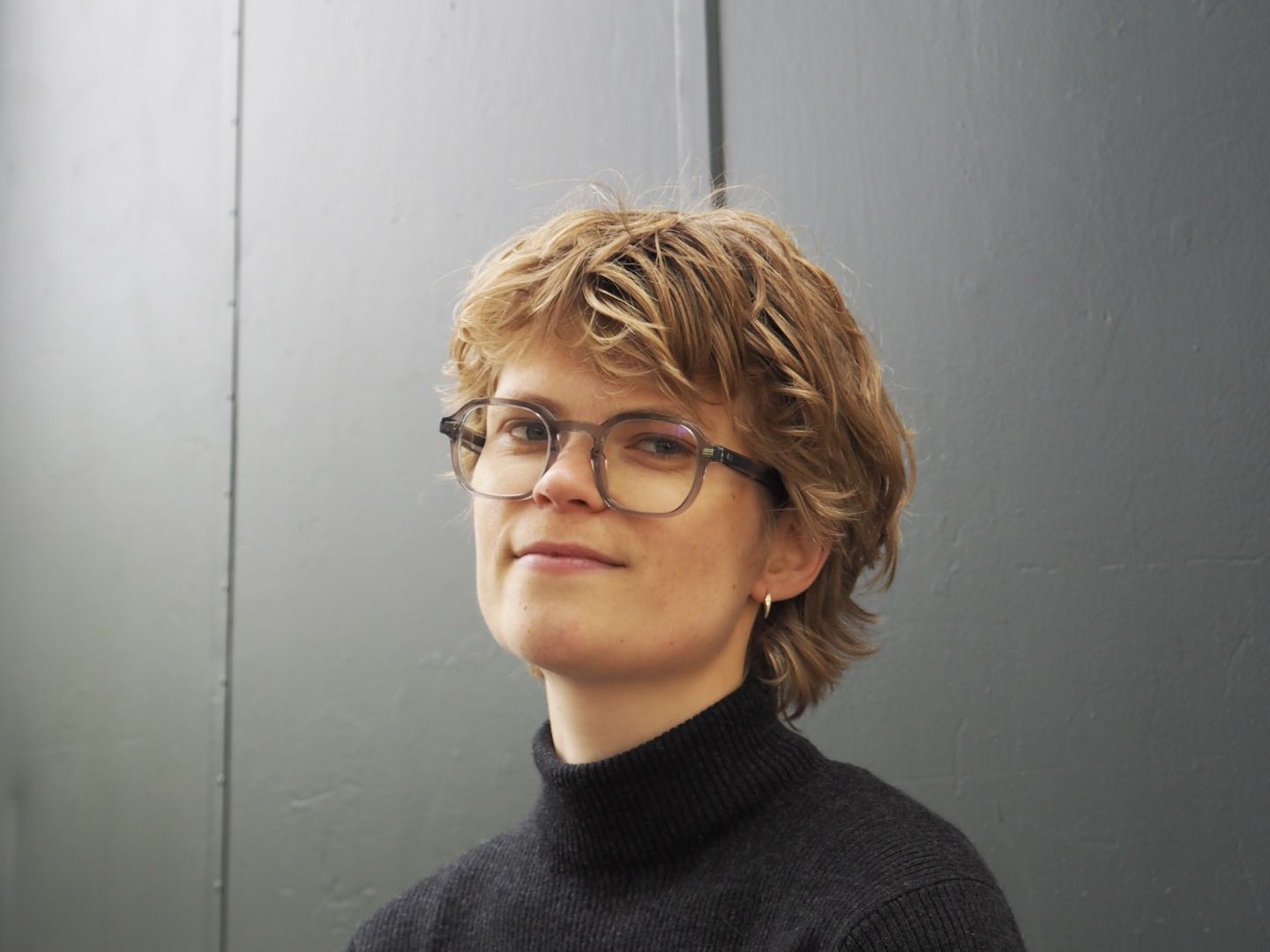 Sofie Boiten steht vor einer grauen Wand.