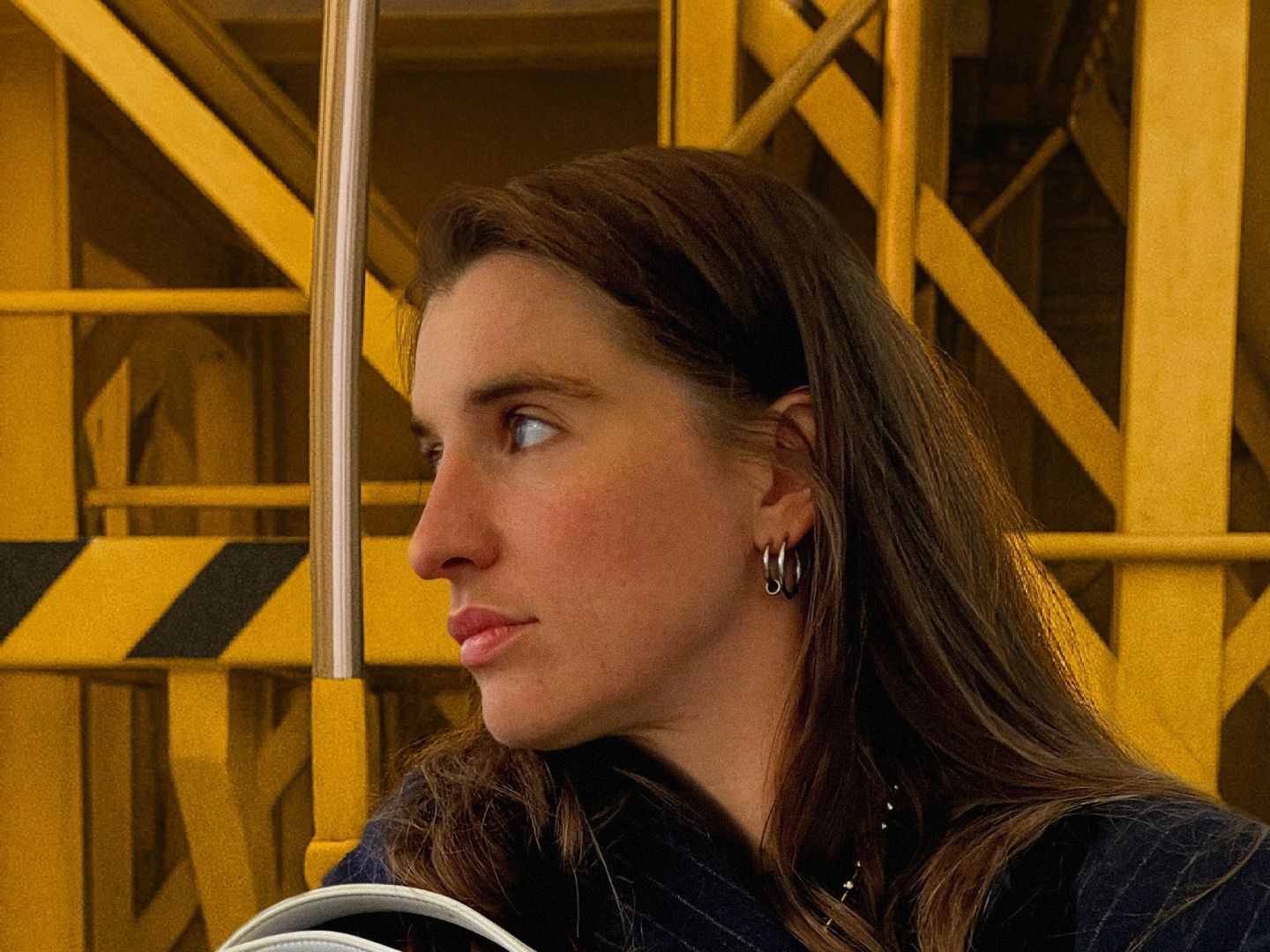 Ein Portraitfoto von Laura Kirst vor einem gelben Gestell.