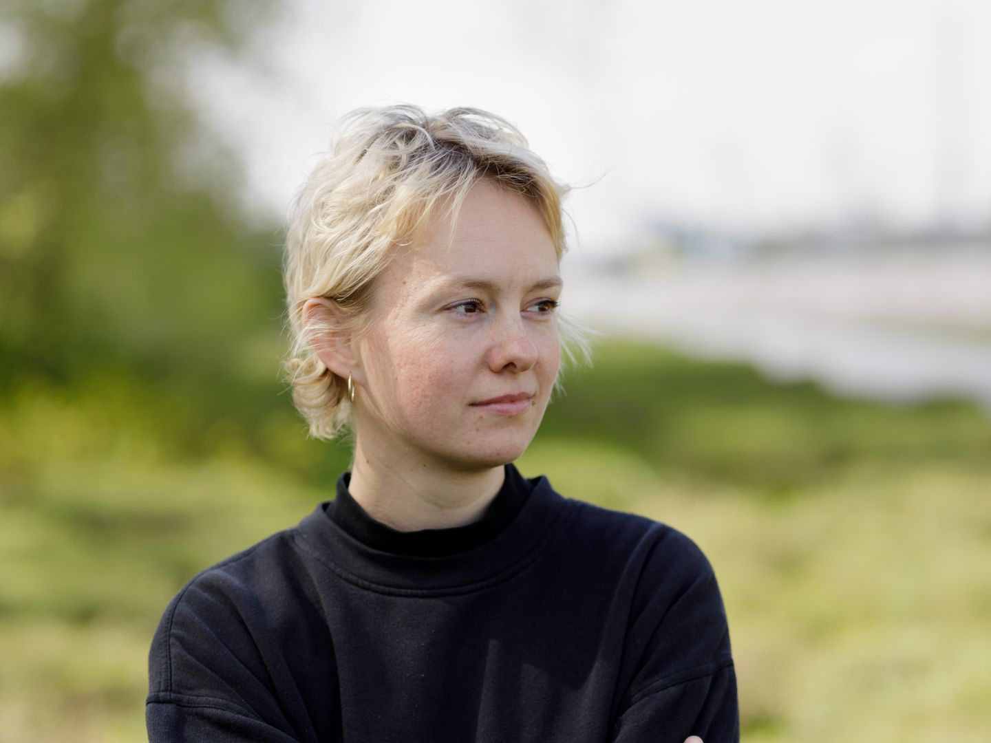Sophie Glaser steht mit überkreuzten Armen auf einer Wiese.