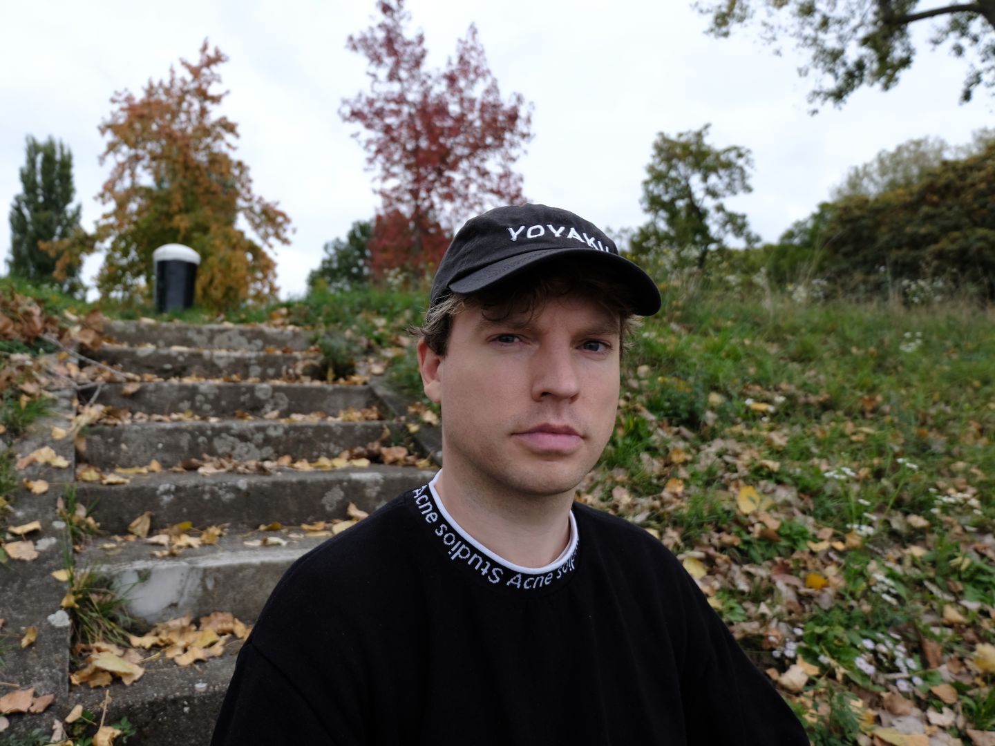 Portraitfoto von Bendrik Grossterlinden vor einer mit Herbstlaub bedeckten Steintreppe