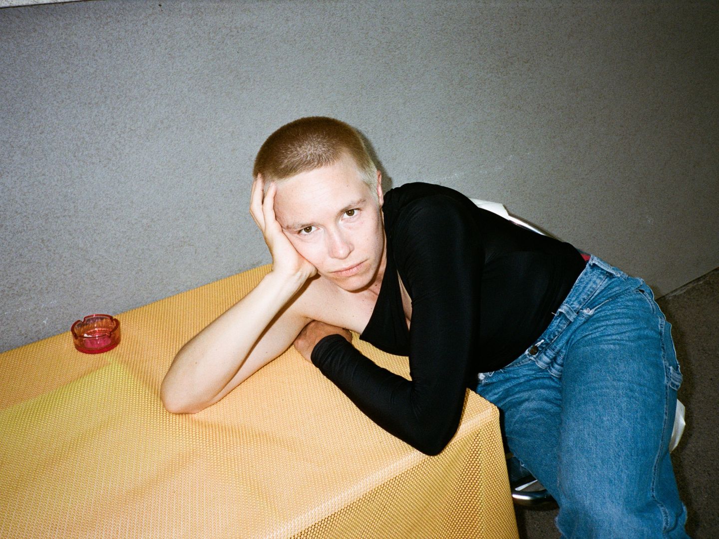 Portraitfoto von Anna Marboe, lehnend an einem kleinen Tisch.