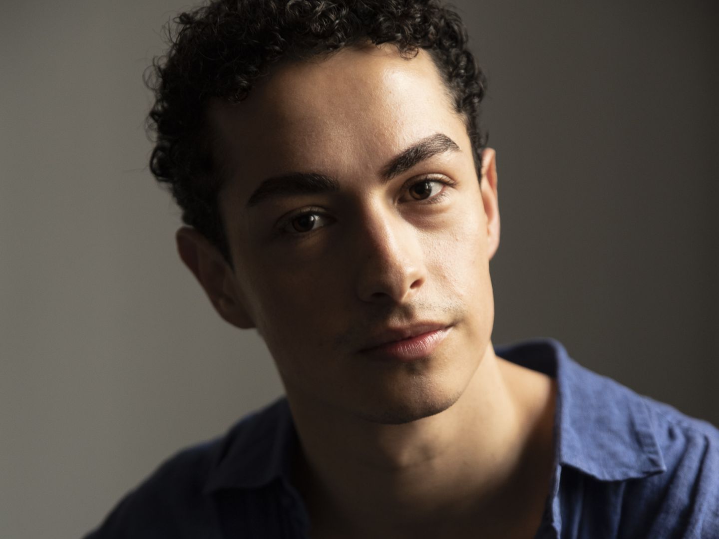 Portraitfoto von Jonathan Joèl Albrecht in blauem Hemd.