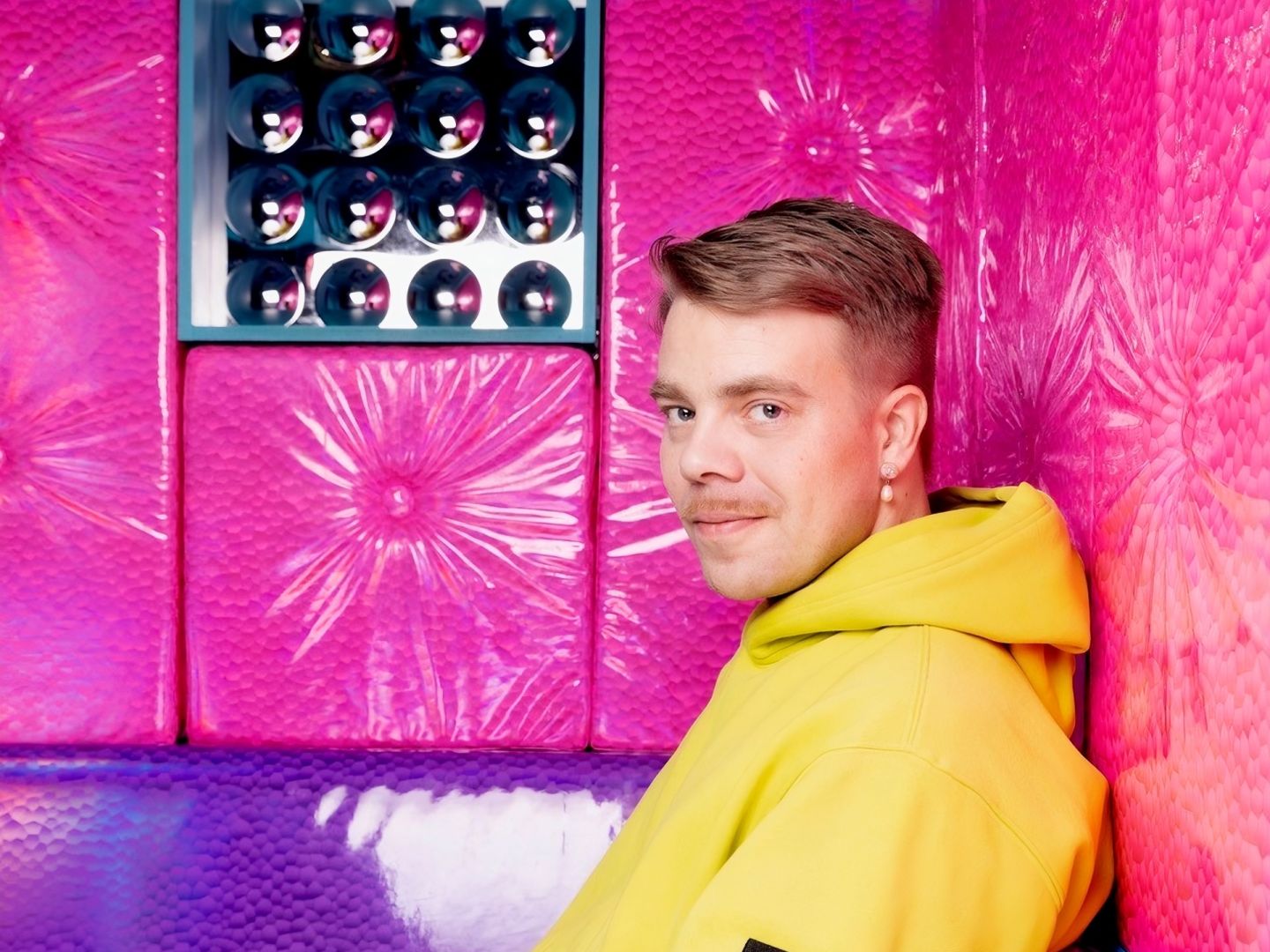 Foto von Heiki Riipinen in einem pink und lila gepolsterten Zimmer.