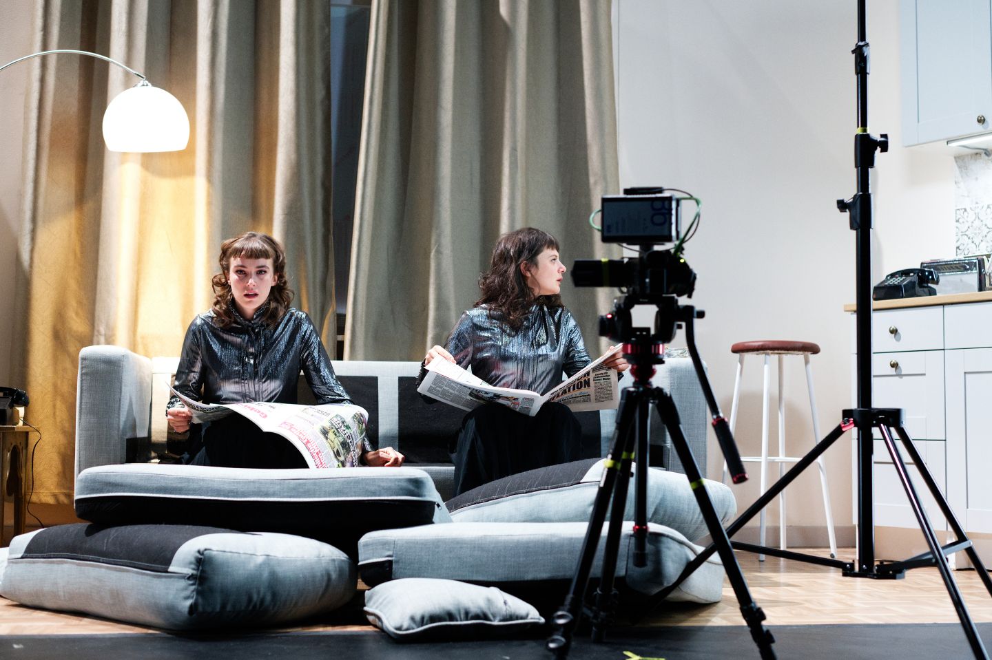 Das Bild zeigt Katharina Blum als zwei Personen, sitzend auf einem verwüsteten Sofa.