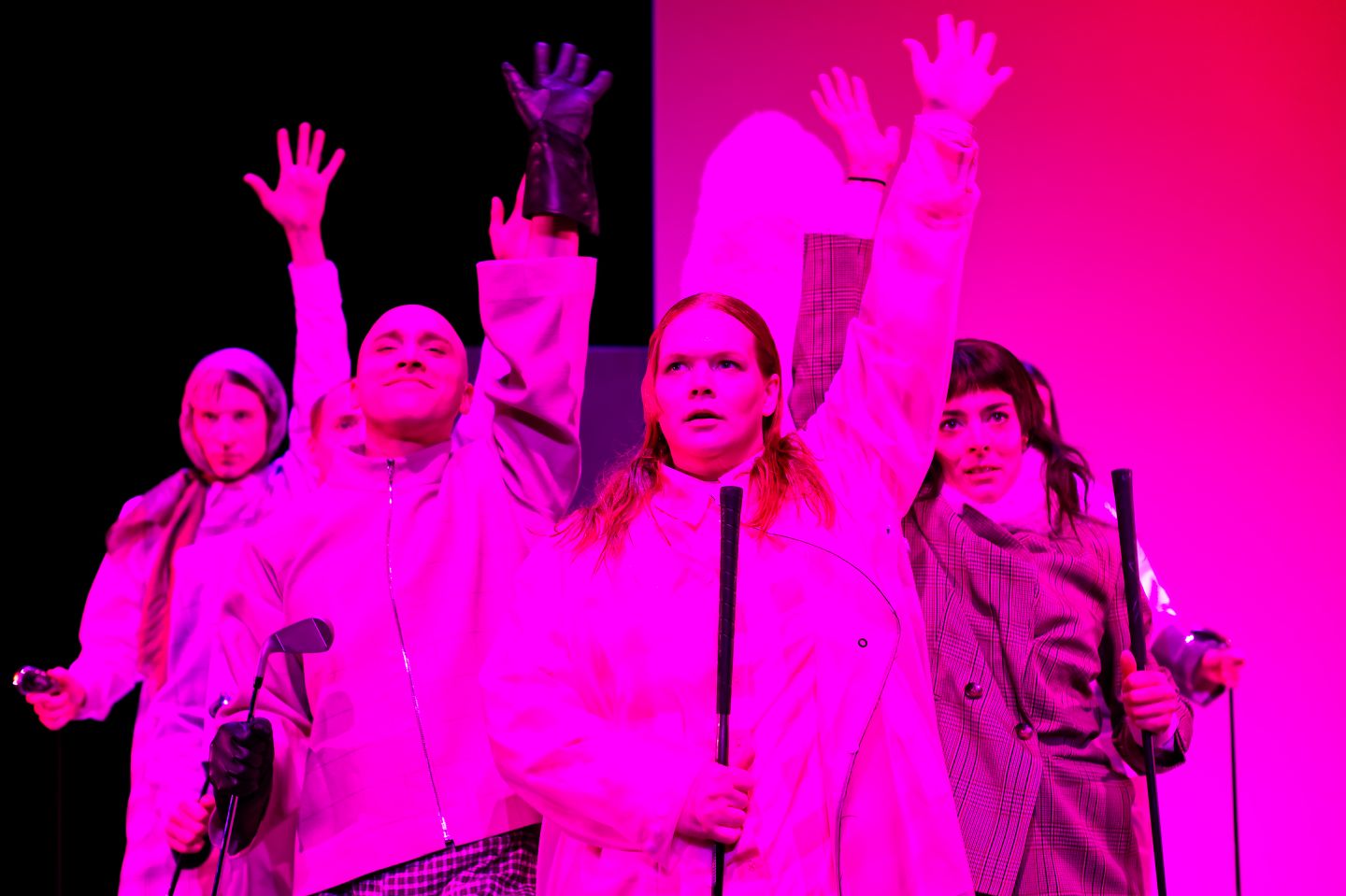 Fünft Personen, pink angestrahlt, recken eine Hand. 