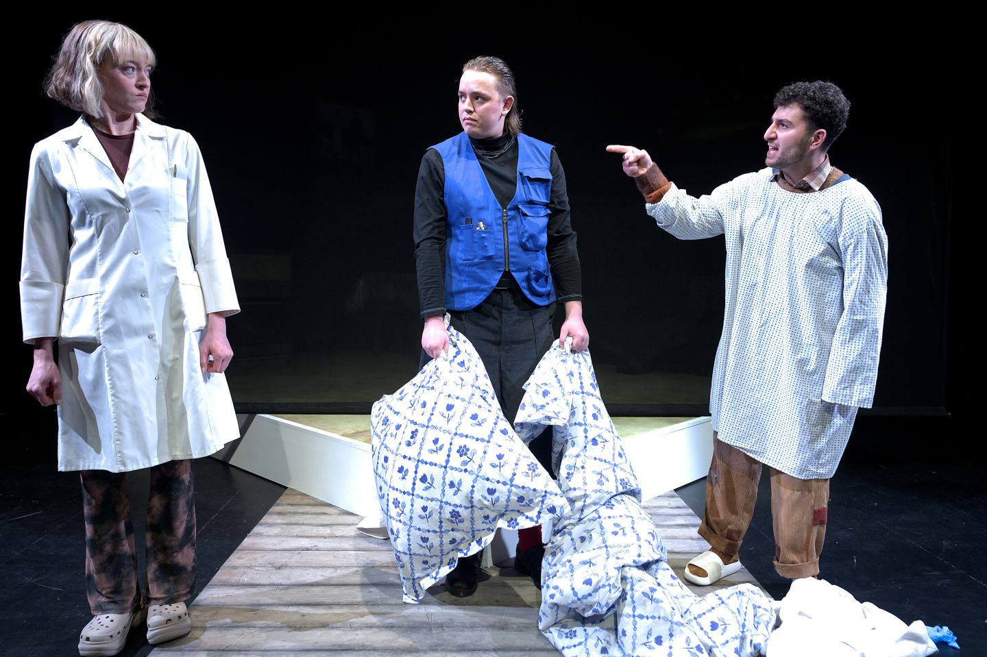 Drei Schauspieler*innen stehen sich gegenüber