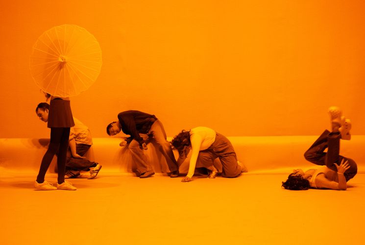 Das Ensemble von &quot;Die Verwandlung&quot; räkelt sich in gelbem Licht.