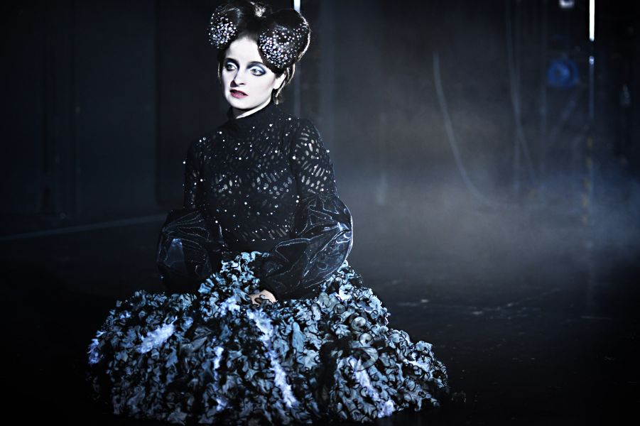 Das Foto zeigt eine Frau in einem blau-schwarzen Rüschenrock mit Samt-Oberteil und glitzerndem Haarschmuck.