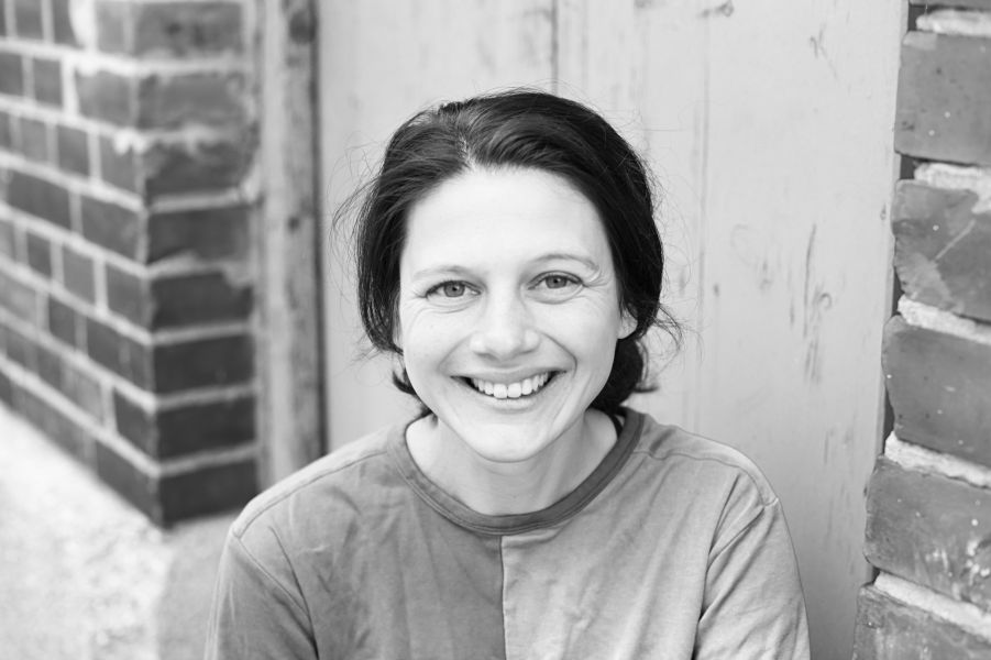Das schwarz-weiße Foto zeigt ein Portrait von Nina Steils lächelnd