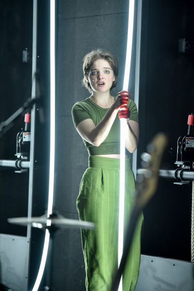 Das Foto zeigt eine Frau in grüner Kleidung, die einen Leuchtstab hält.