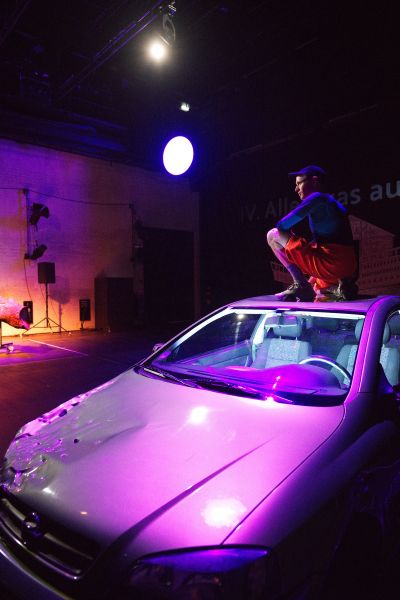 Das Bild zeigt einen Mann, der auf dem Dach eines Autos kniet.