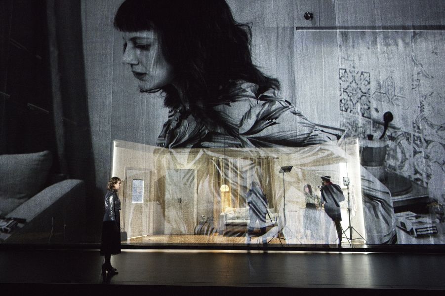 Das Bild zeigt das gesamte Bühnenbild, Katharina Blum steht am vorderen Bühnenrand mit dem Rücken zum Publikum.