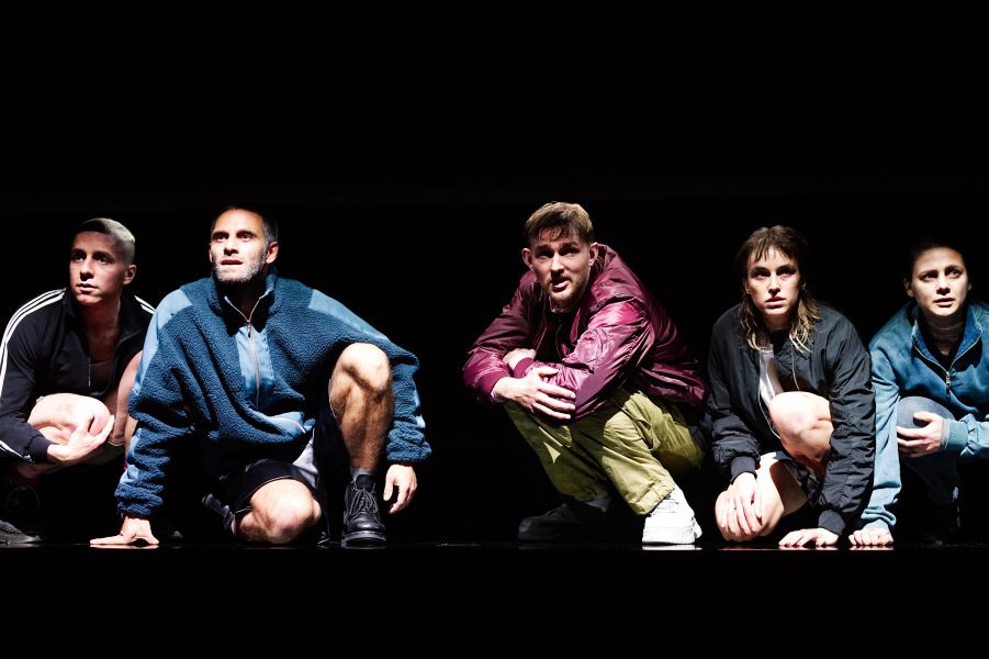 Die Rollen von Julian Gutmann, Jonathan Müller, Max Poerting, Ruth Bohsung und Nina Steils sitzen auf dem Boden und blicken zusammengekauert in die Ferne.