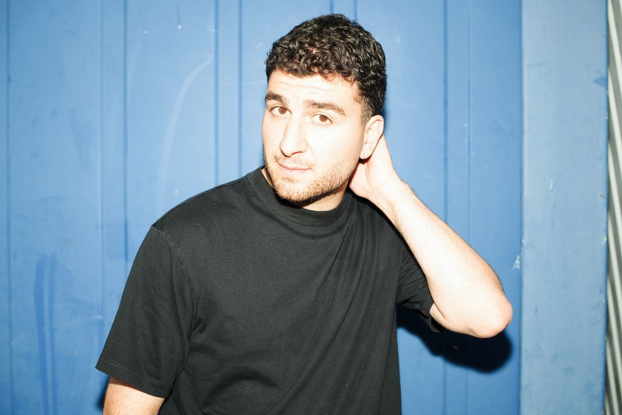 Portraitfoto von Baran Sönmez vor blauem Hintergrund