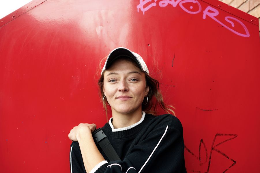 Portraitfoto von Lola Dockhorn vor einer roten Wand