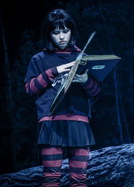 Gio Yoo blättert mit ernstem Ausdruck durch ein Fotoalbum.